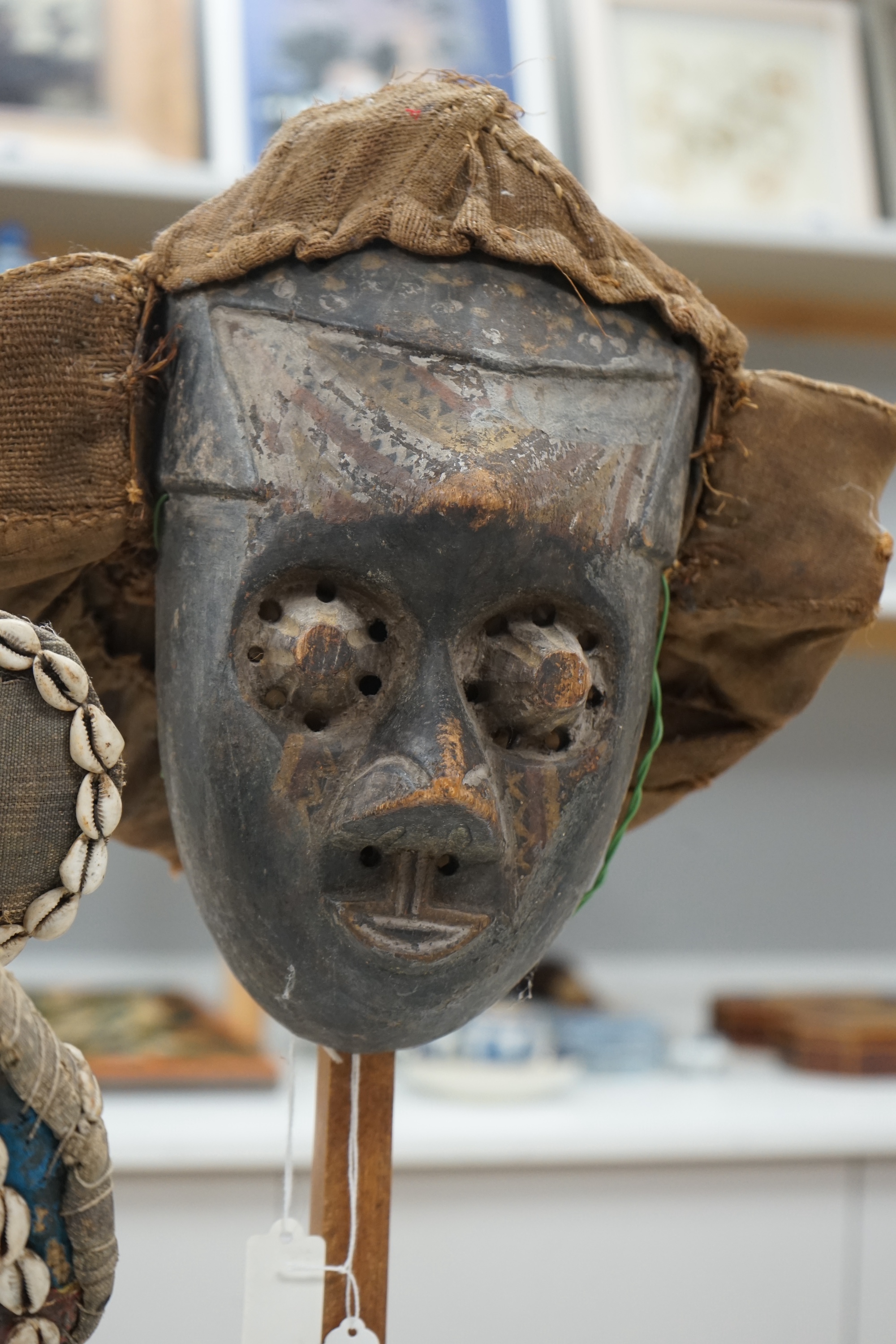 An African Ivory Coast/Liberian Dan mask together with another from the Democratic Republic Congo, both on stands, tallest 58cm including stand. Condition - some damage to the fabric of hats